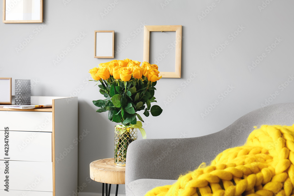 Vase with beautiful yellow roses on table in interior of room - obrazy, fototapety, plakaty 