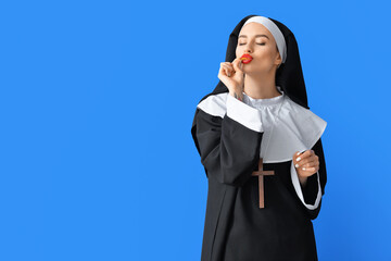 Wall Mural - Sexy nun eating chips on color background