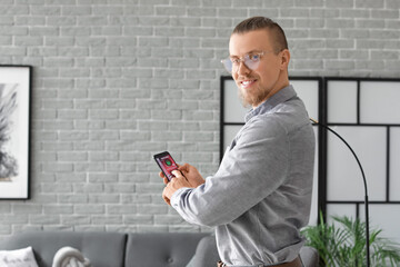 Canvas Print - Man with mobile phone using smart home security system application