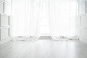 Backlit window with white curtains in empty room