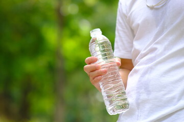 Canvas Print - Bottle of water in green natural background and space