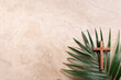 Palm Sunday concept. Wooden cross over palm leaves. Reminder of Jesus sacrifice and Christ resurrection. Easter passover. Eucharist concept. Christianity symbol and faith