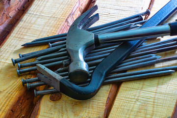 Tools such as a crowbar and a hammer lying on a wooden floor.