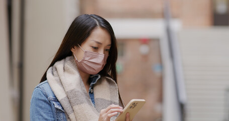 Wall Mural - Woman wear face mask and use of smart phone