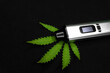 electronic vaporizer with cannabis leaf on black background