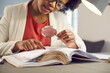© Studio Romantic - Young african american business woman reading financial report, archive document looking through magnifying glass lens. Fraud information search, effective checkout and project result investigation