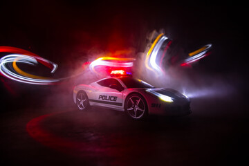 Wall Mural - Police car chasing a car at night with fog background. 911 Emergency response police car speeding to scene of crime. Selective focus