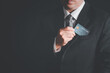 © kwanchaichaiudom - Businessmen take out the credit card from the suit pocket on black background,