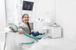 © Ihor - Happy young girl smiling, sitting in dental chair, copy space