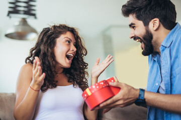 Wall Mural - Man giving a surprise gift to woman at home