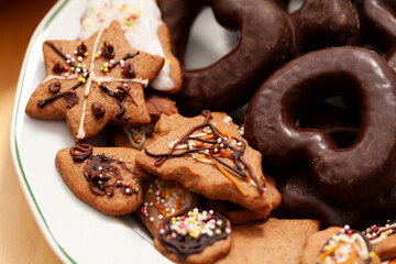 Simple fresh decorated homemade tasty holiday gingerbread cookies and chocolate cookies laid out on a plate, set detail, closeup. Home made pastries, crunchy christmas cookies up close, from above