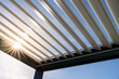 © mathilde - Trendy outdoor patio pergola. the sun's rays pass through the metallic structure