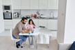 © insta_photos - Happy young indian parent father helping teenage child daughter distance learning at home. Teen school kid girl studying in kitchen with dad having virtual online class together. Remote education.