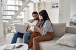 © insta_photos - Young indian couple checking paper bills paying mortgage loan bank debt online together on computer, calculating taxes, expenses, making payments, planning family budget finances using laptop at home.