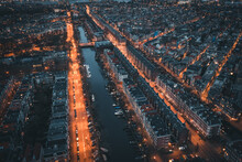 Amsterdam, Netherlands. Aerial Top View Of Old City From Above At Night With Canals And Houses.