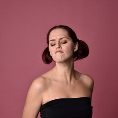 Sticker - Close up portrait of a red haired woman with expressive facial features on a pink studio background.