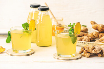 Composition with healthy ginger juice on light wooden background