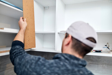 Wall Mural - Handyman worker assembling furniture and fixing it.