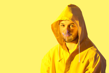 Wall Mural - Toned portrait of handsome young man with plastic mask on color background