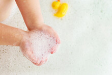 Little Baby Girl Playing With Foam In A Bath Tub. Child Playing With A Toys In The Bathroom.