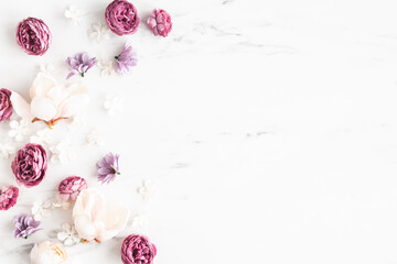 Flowers composition. White and purple flowers on marble background. Flat lay, top view