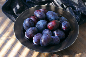 Wall Mural - Fresh blue plums in black plate