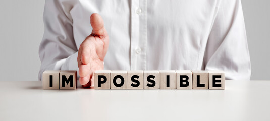 Wall Mural - Businessman hand changes the word impossible into possible