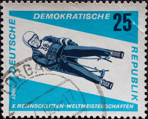 GERMANY, DDR - CIRCA 1966  : a postage stamp from Germany, GDR showing an athlete on the men's single-seater luge. Luge World Championships