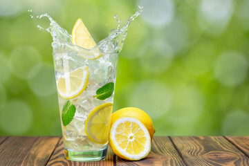 Sticker - lemonade in glass on wooden table with green blurred background