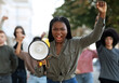 Emotional black lady activist with megaphone on the street
