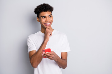 Sticker - Photo of cheerful guy hold telephone finger chin look empty space wear white t-shirt isolated grey background