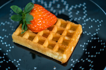 Wall Mural - waffle with strawberries on a black plate