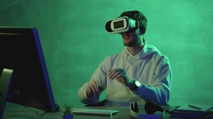 Man using a VR headset and a computer on a colorful background