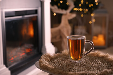 Sticker - Glass of hot drink near fireplace in room. Space for text