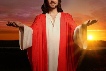 Poster - Jesus Christ with outstretched arms outdoors at sunset