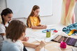 © Svitlana - Adorable girls drawing clothes patterns in sewing workshop