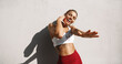 © Liubov Levytska - Female runner dancing, listening music in wireless earphones, stretch out hand and smiling. Female athlete jogger enjoy workout training outdoors, having fun on morning jogging, exercising