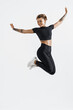 © Liubov Levytska - Female fitness girl jumping, freeze in air silhouette of young woman runner, athlete smiling and posing free, wearing sportswear outfit for workout on white background