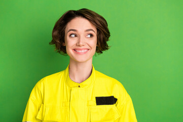 Canvas Print - Photo of young cheerful woman firefighter happy positive smile look empty space isolated over green color background