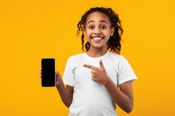 Black girl showing blank empty smartphone screen and pointing