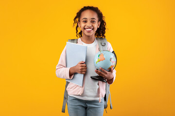 Wall Mural - Cheerful young black girl holding Earth world globe and notebook