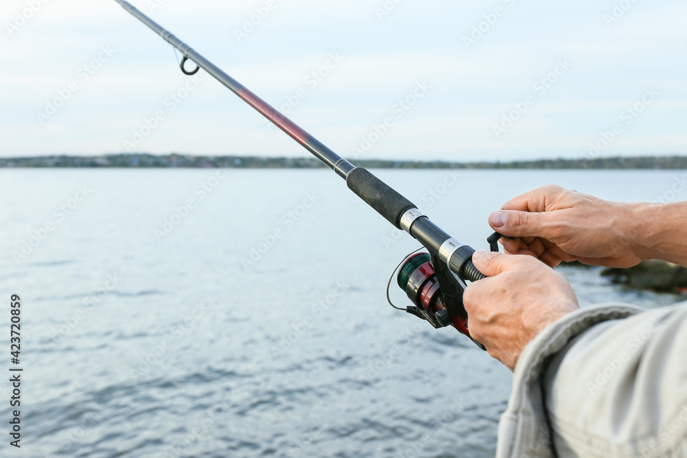 Man fishing on river bank, closeup