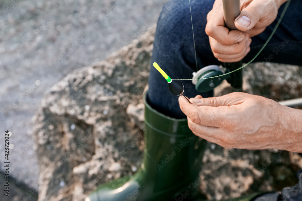 Man fishing on river bank, closeup