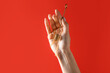 Hand with honey dipper on color background. Erotic concept