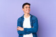 © luismolinero - Teenager caucasian  handsome man isolated on purple background happy and smiling