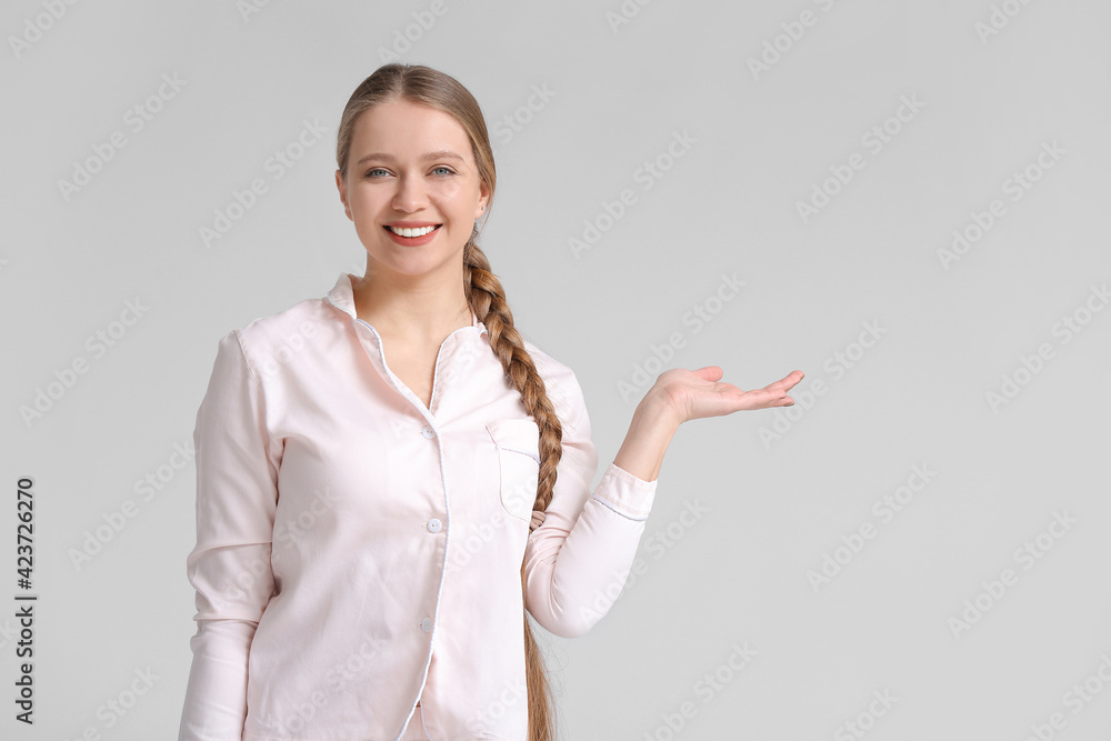 Beautiful smiling young woman on grey background