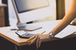 © jiradet_ponari - Hand of Business woman standing near office desk with computer monitor
