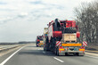 © Kirill Gorlov - Many heavy industrial truck with semi trailer platform transport disassembled combine harvester machine on common highway road on sunset or sunrise day. Agricultural equipment transportation service
