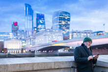 Man Using Phone Near London Bridge, London, UK