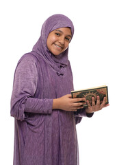 Wall Mural - Happy Beautiful Arab Muslim Girl in Islamic Fashion Dress Holding Holy Book of Quran With Happy Smily Face